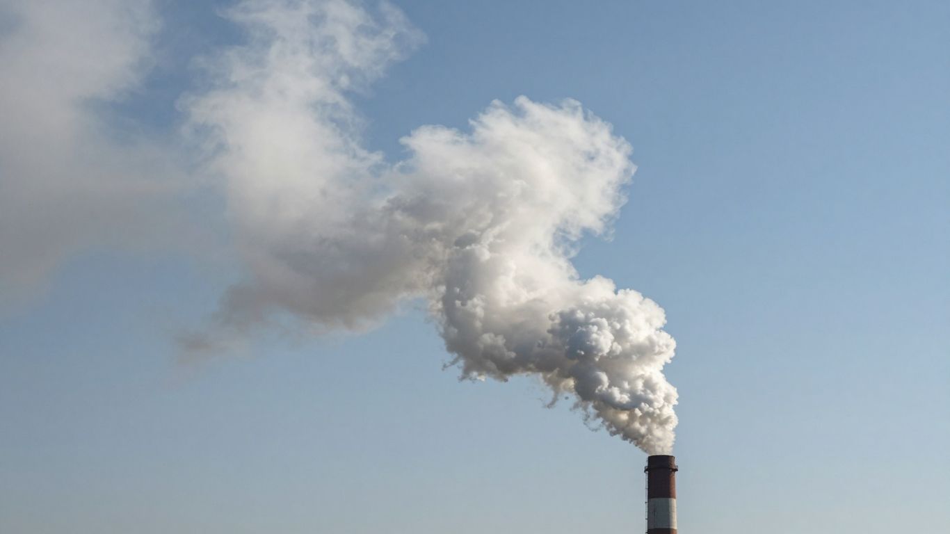 Smoke plume rising from a chimney into the sky.