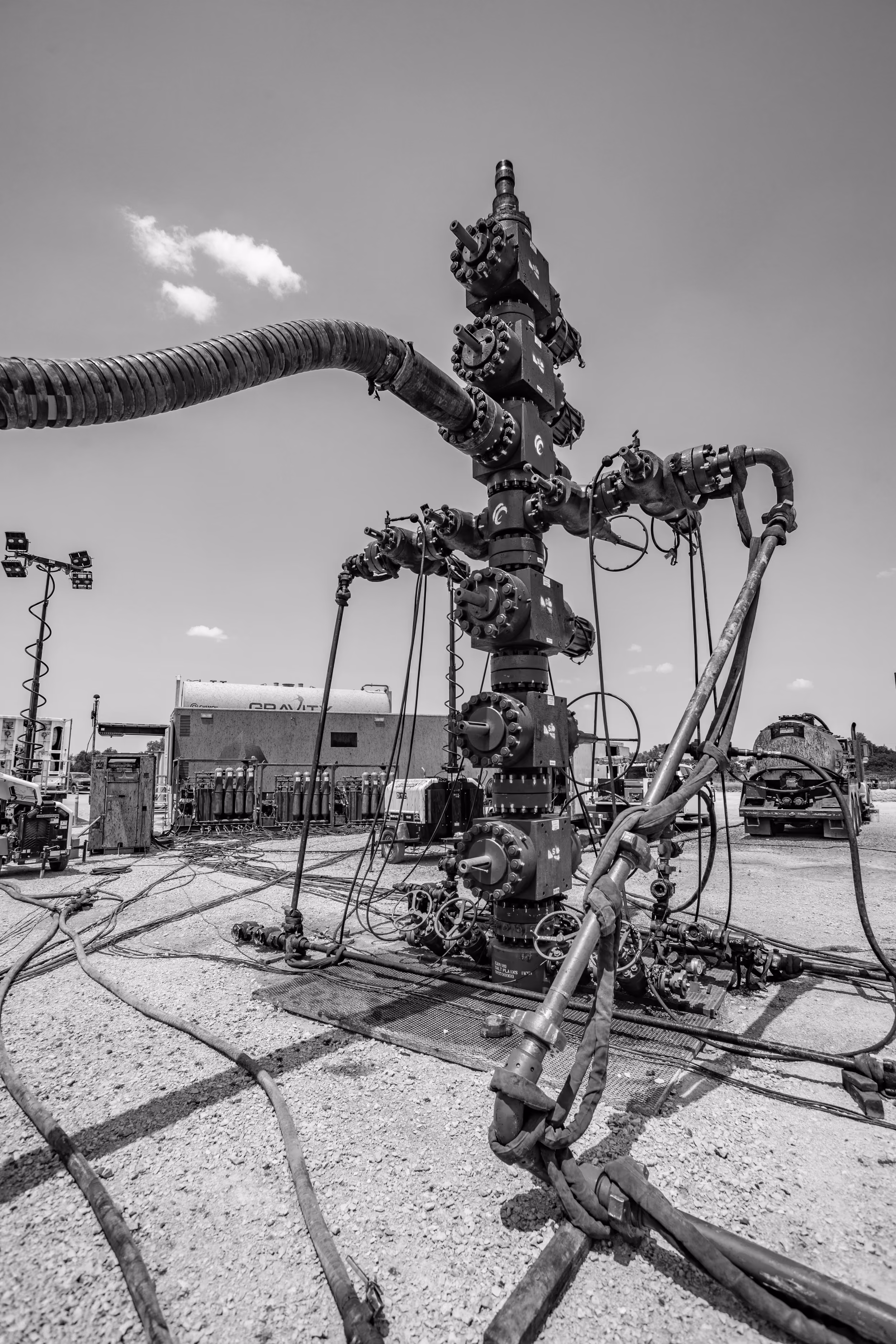 Wellhead with frac iron and hoses connected on a completions location