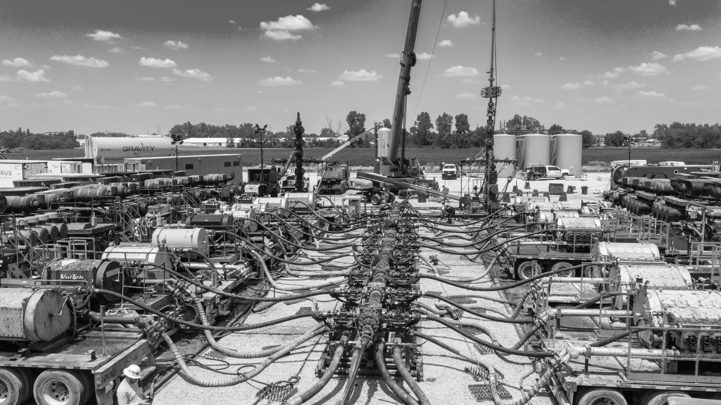 Frac spread of pump trucks and manifold lines on a well pad
