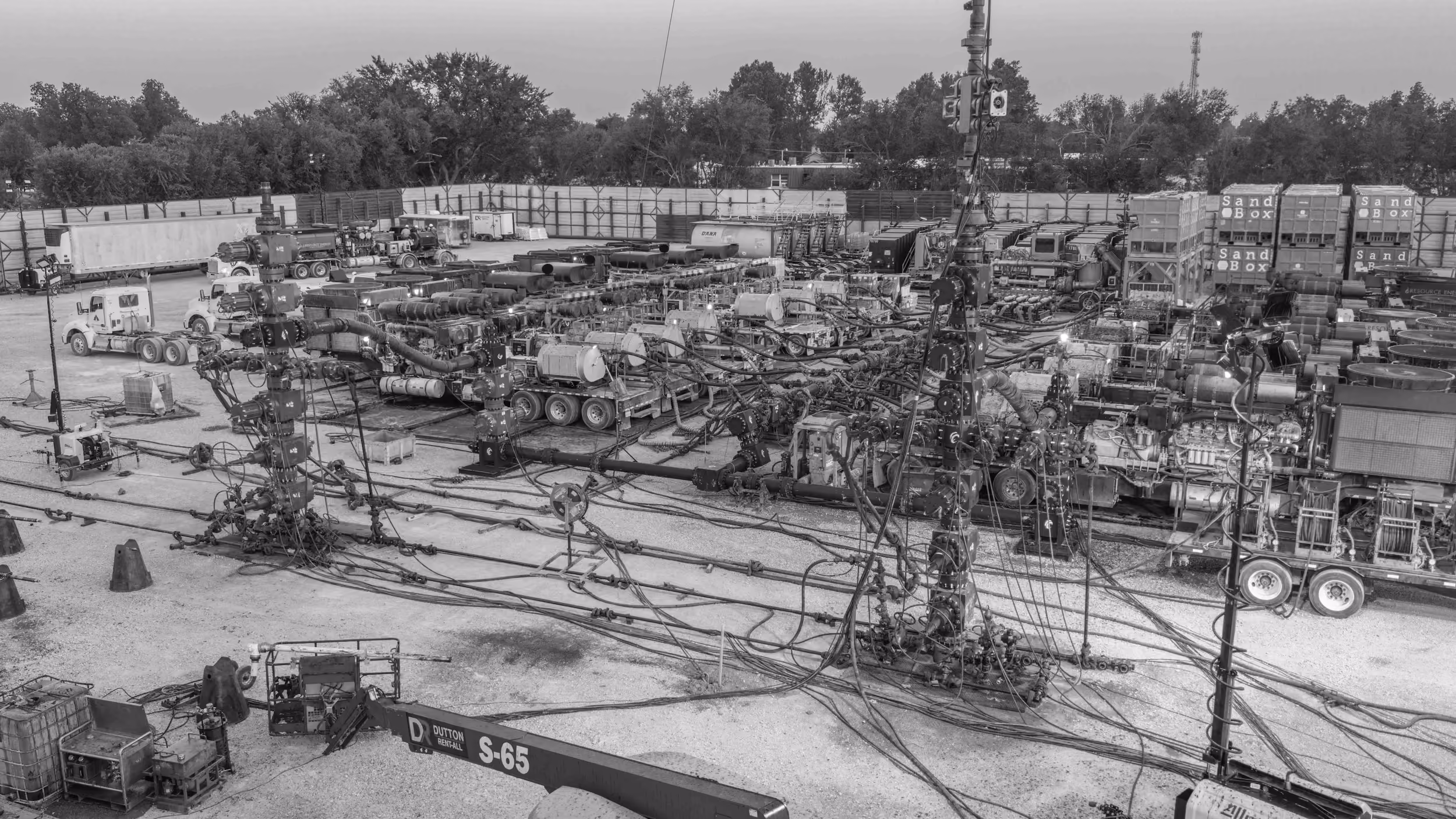 Aerial view of a completions site with trucks, tanks and equipment