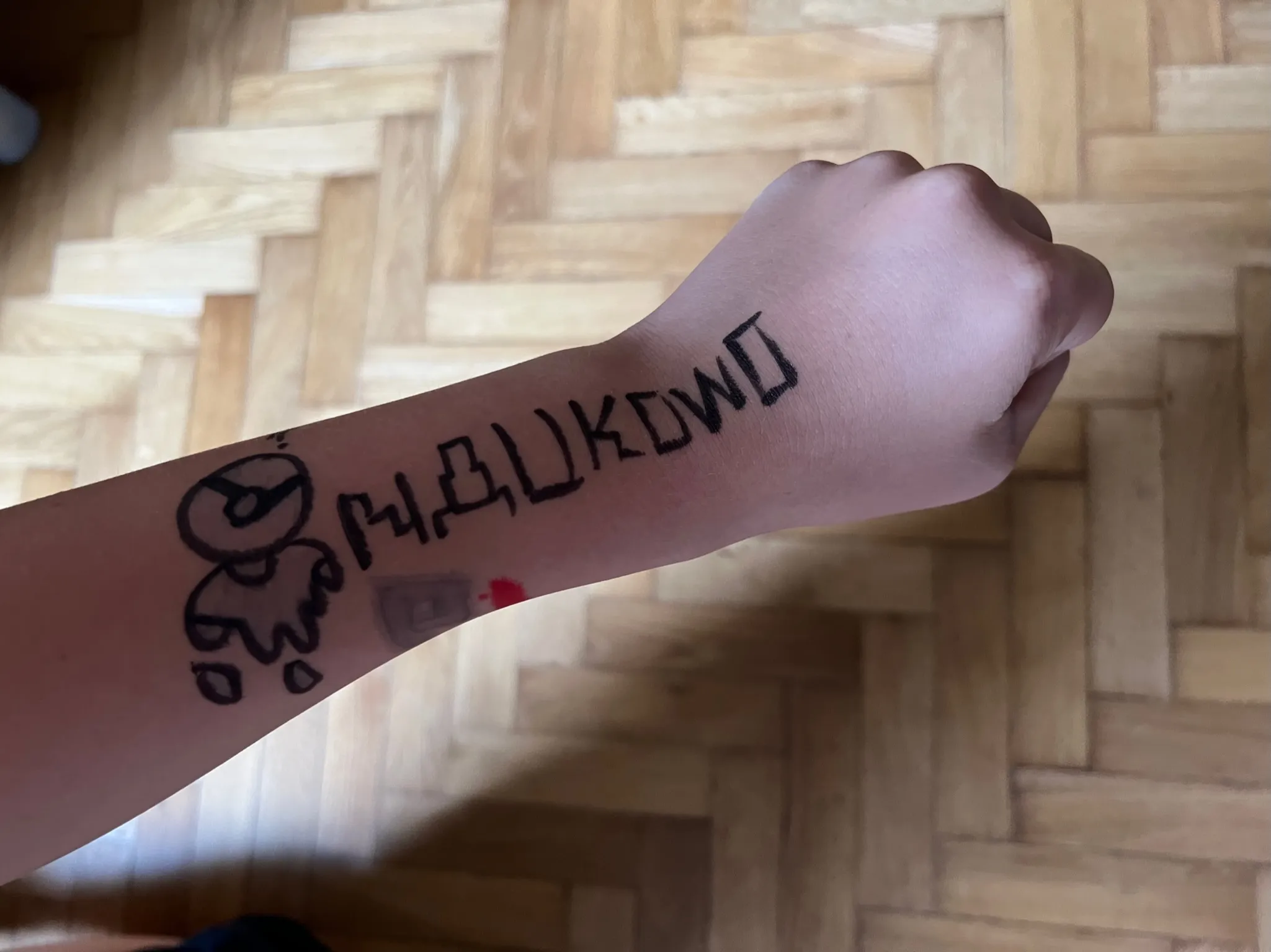 Ręka ucznia z namalowaną nazwą firmy Naukowo w Grodzisku Mazowieckim