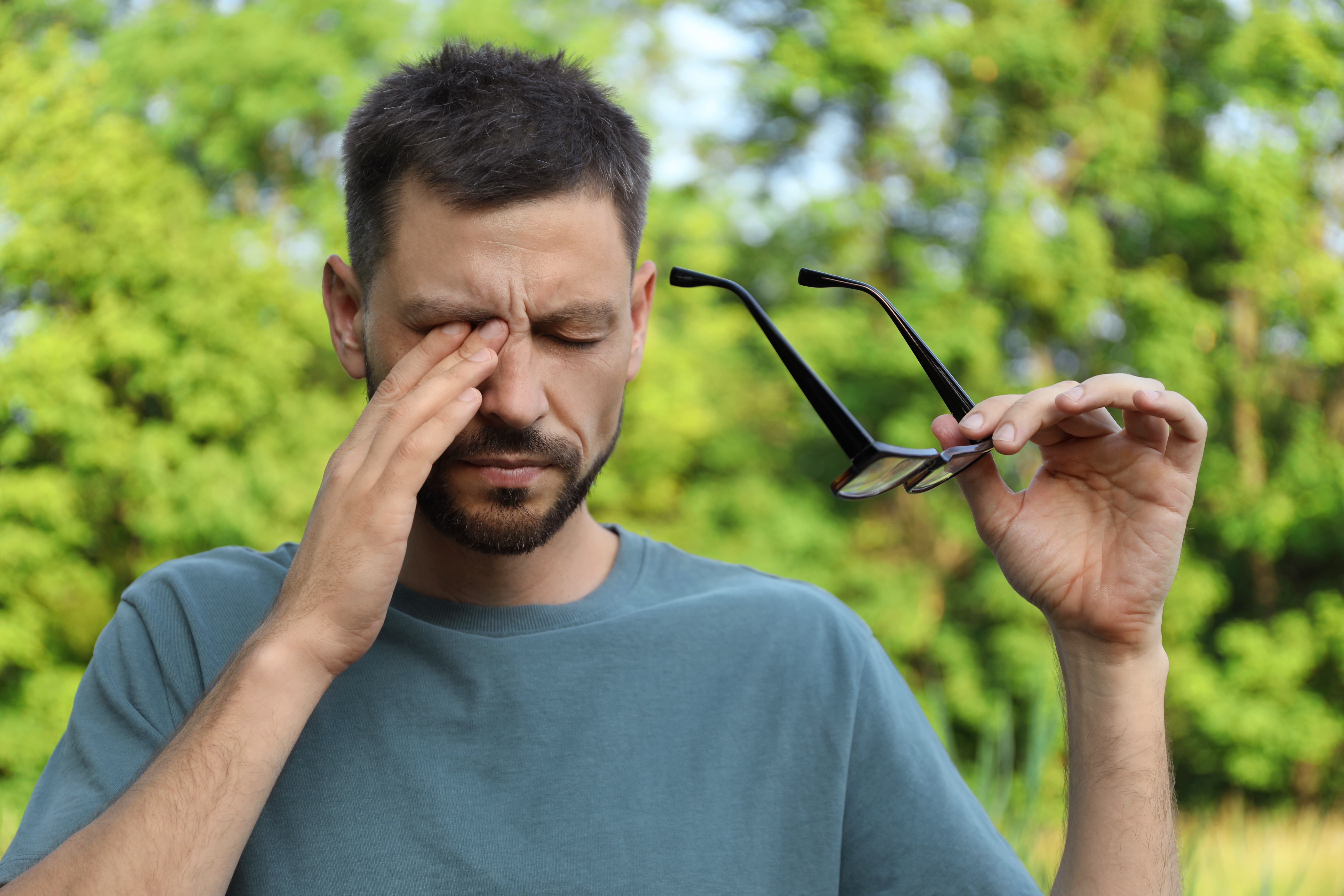 Patient applying artificial tear drops for dry eye relief