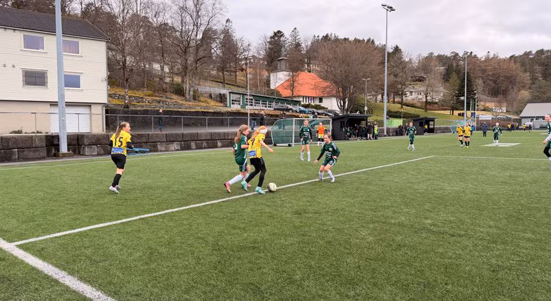 Barn spiller fotball på kunstgressbanen til Eik Fotball