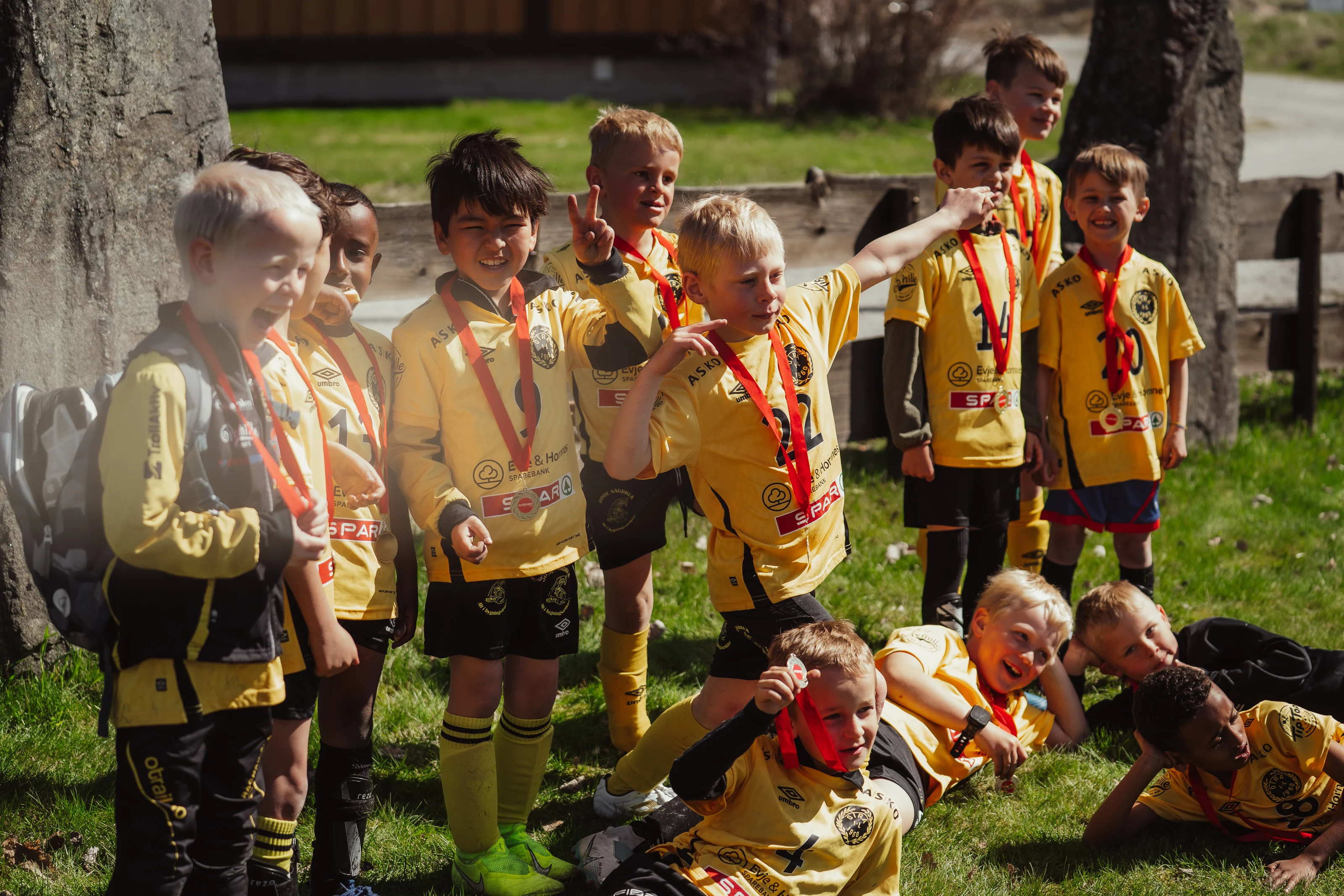 En gjeng med gutter som koser seg på en fotballbane etter å ha tildelt diplomer.