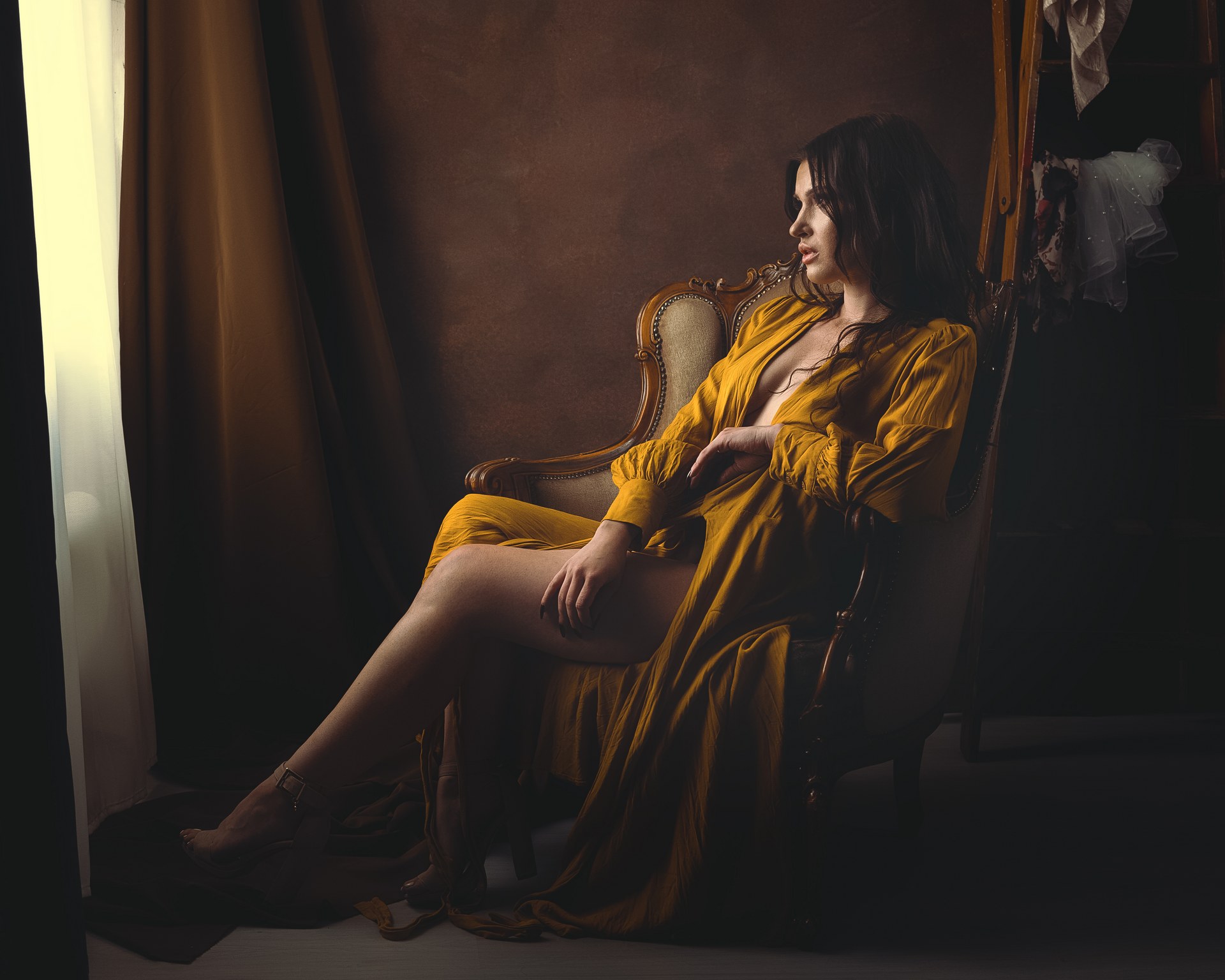 Pitkähiuksinen nainen boudoir tyylisessä muotokuvassa studiossa.
