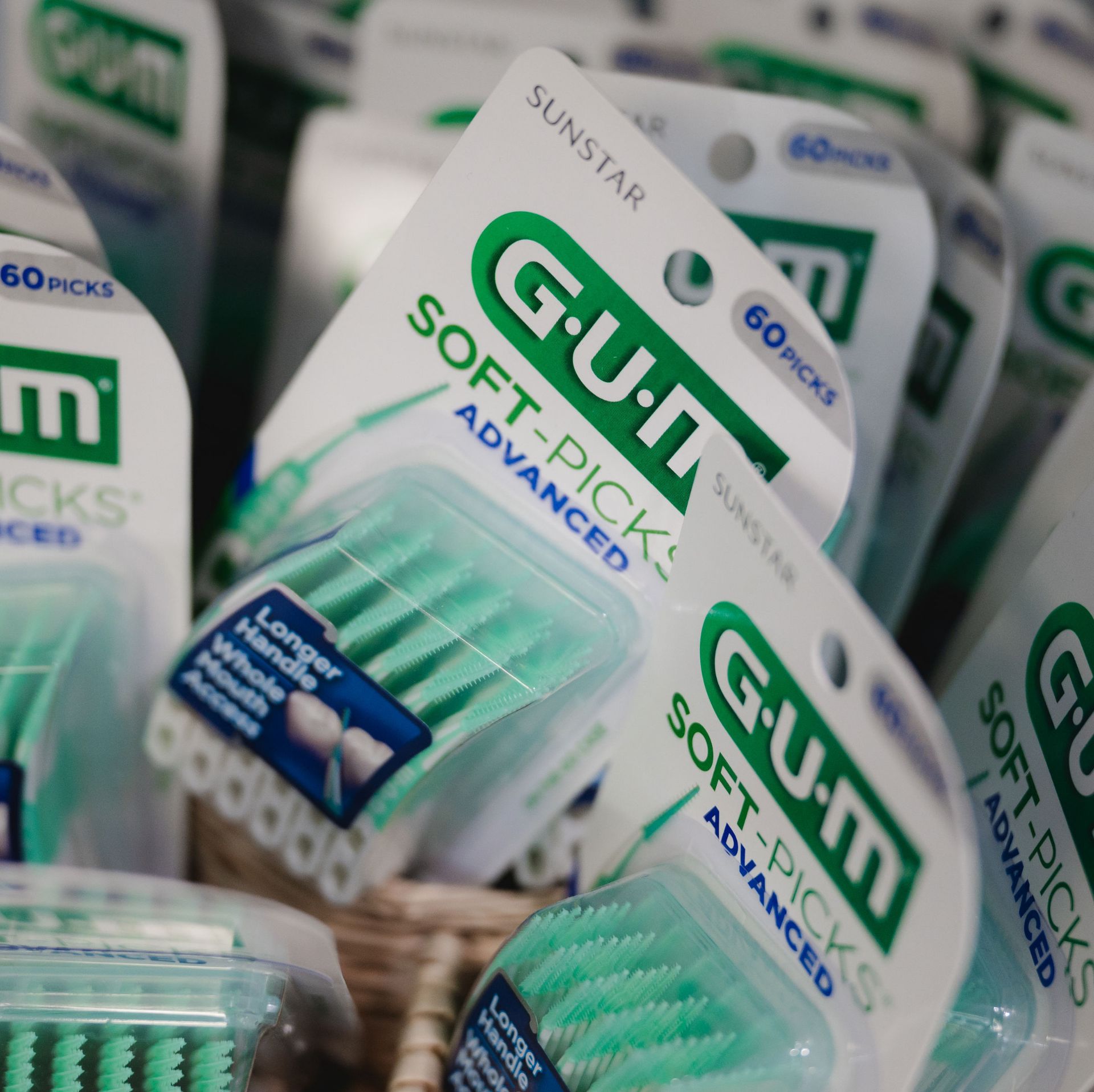 Packages of GUM Soft-Picks Advanced dental picks with green bristles and longer handle for whole mouth access, displayed closely together.