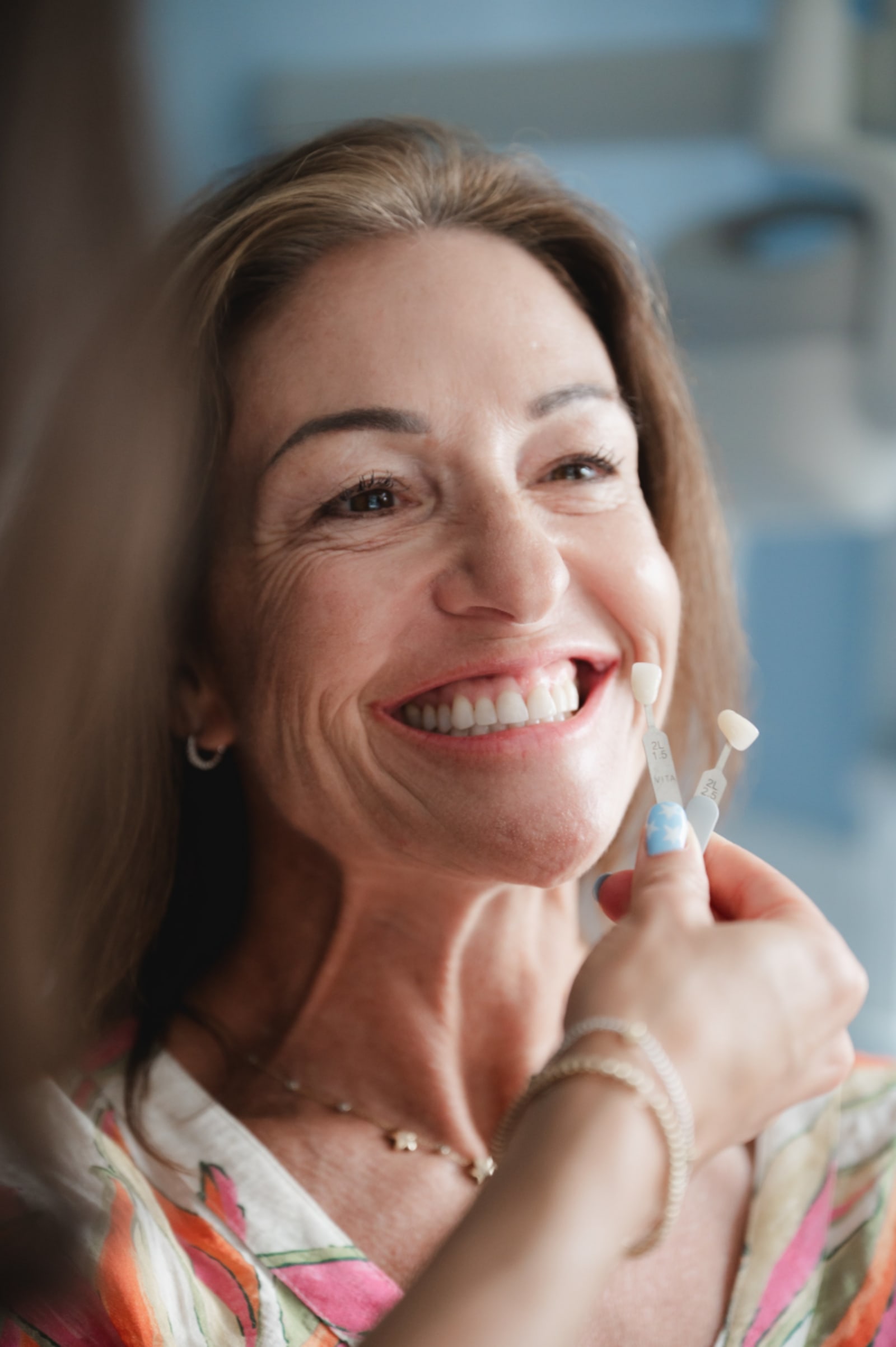 Woman smiling and pointing to her teeth showing results