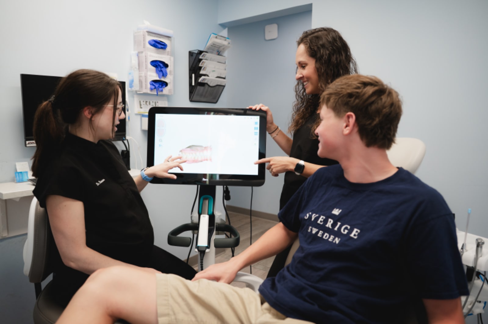 Dental team reviewing digital scan results with patient on computer