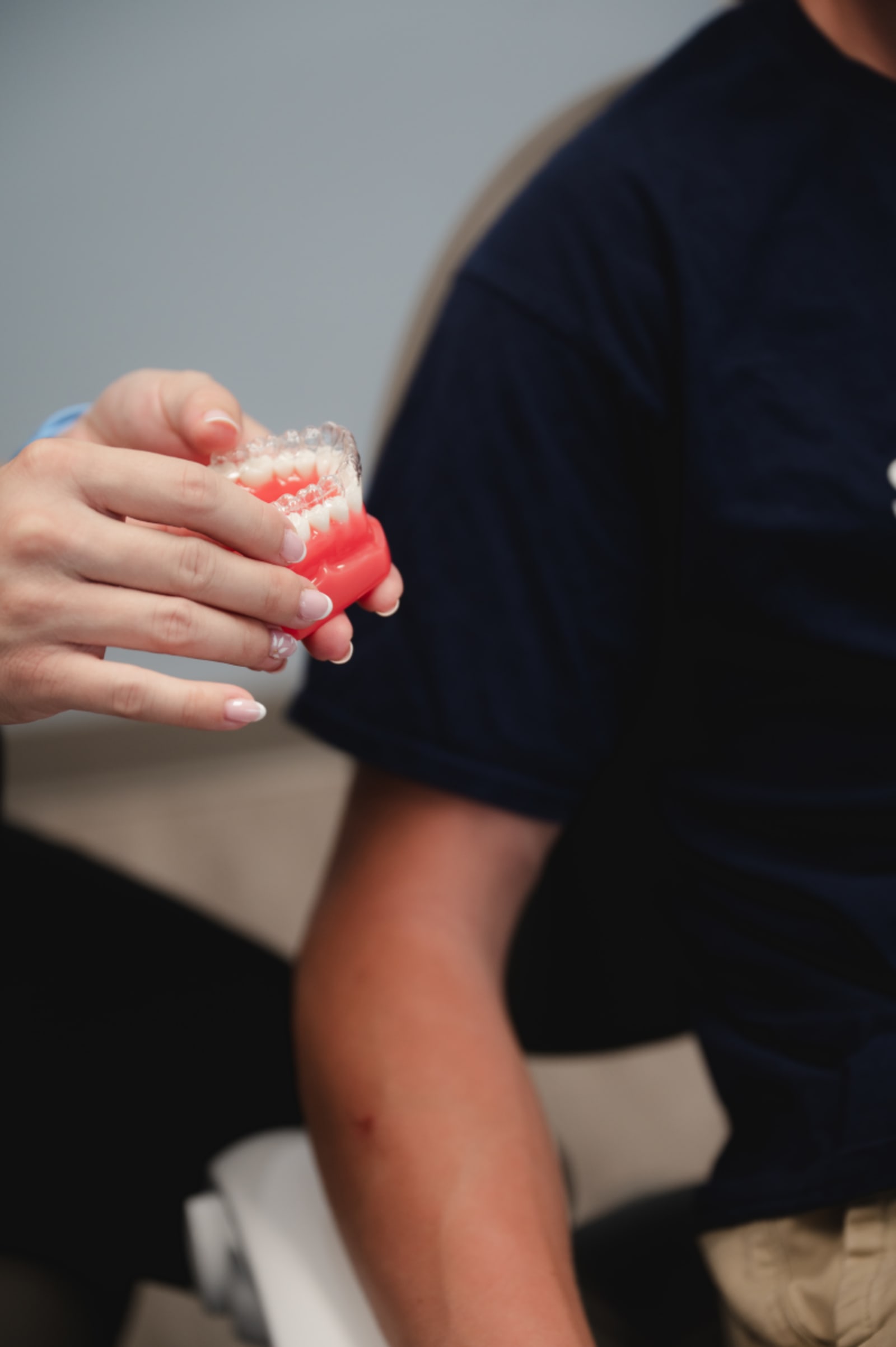 Close-up of dentist holding finished dental crown in patient's hand