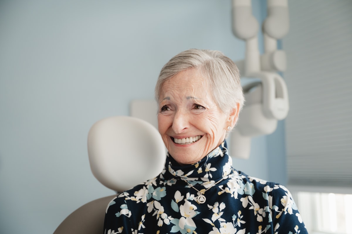 Smiling mature woman with bright, white teeth in a dental treatment room
