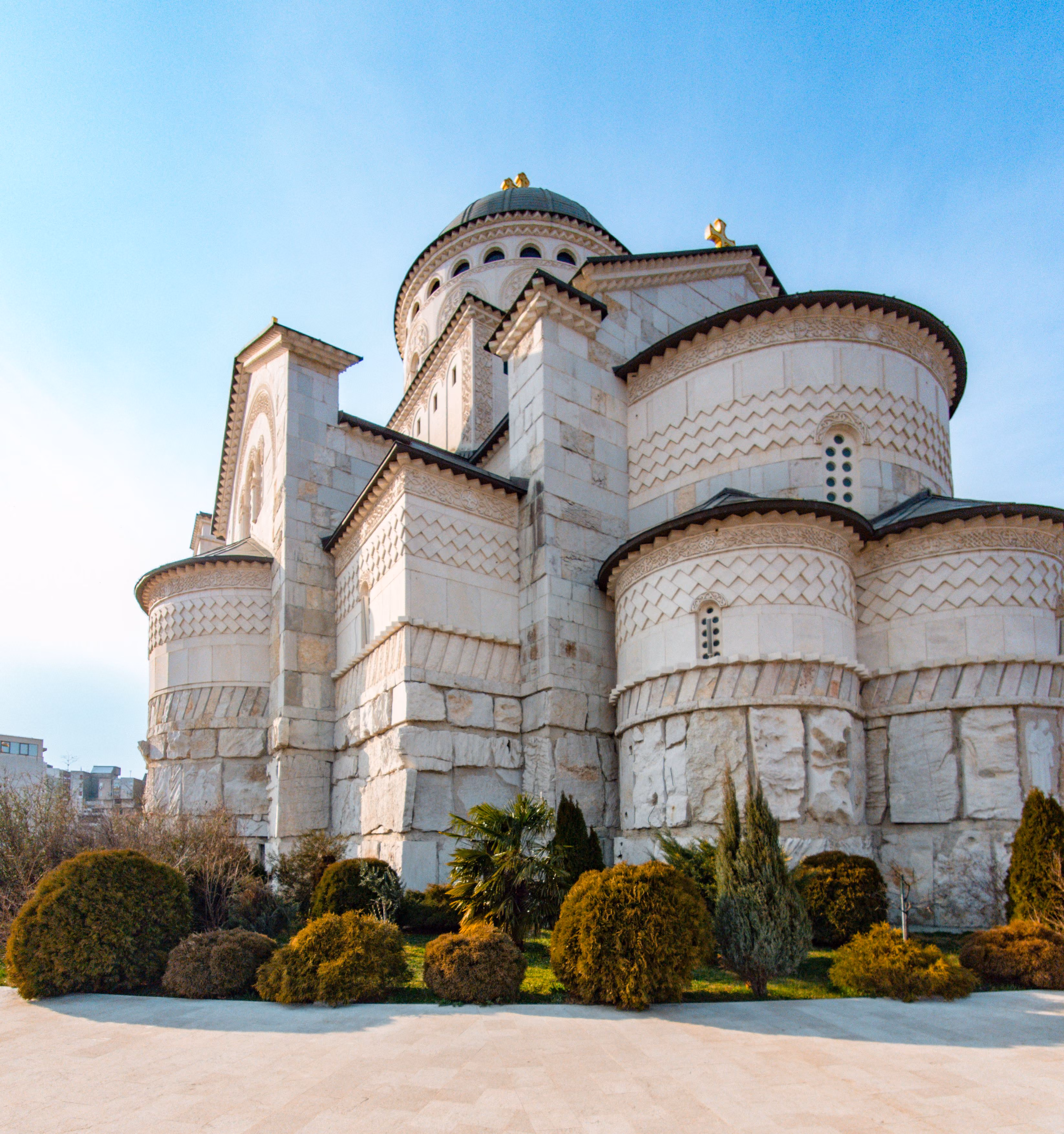 White Orthodox church with domes and landscaped gardens