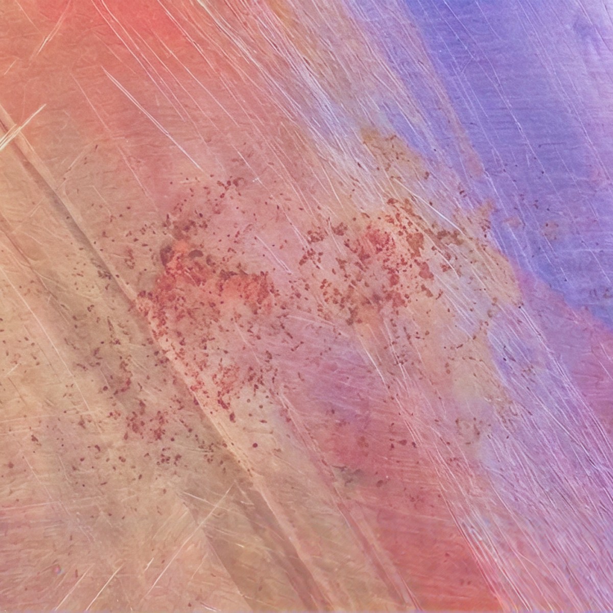 Abstract brushed metal surface in warm pinks, golds and violets.