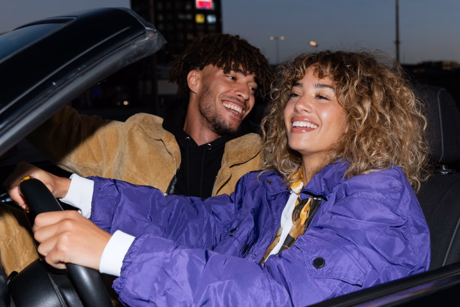 Zwei Personen lachen im Auto, die Abrechnung läuft automatisch im Hintergrund