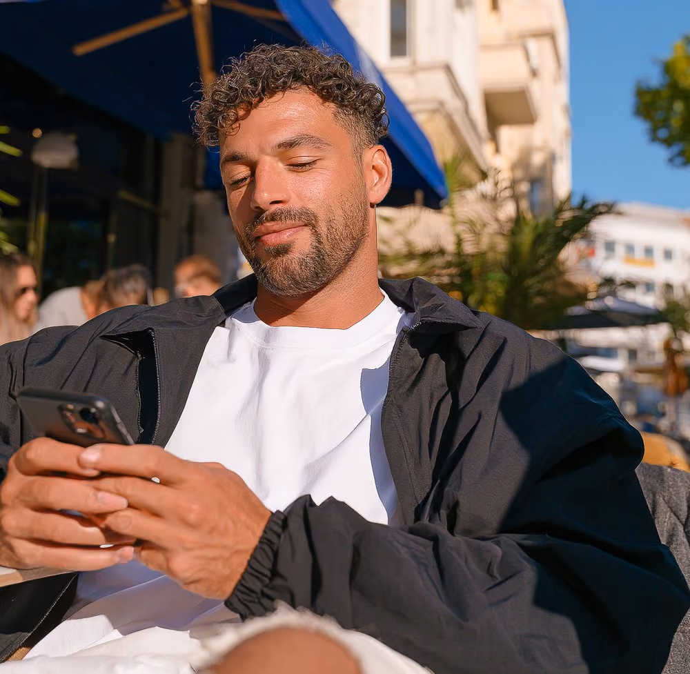 Mann mit Handy, davor die Liste der laufenden Parkvorgänge