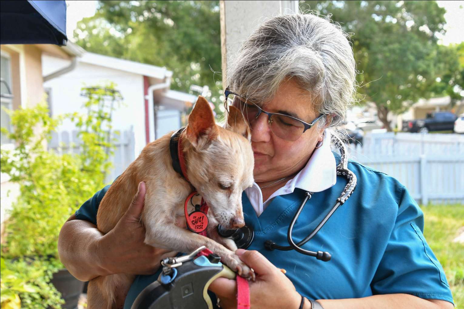 Dr. Rivera cuddling a small dog outdoors