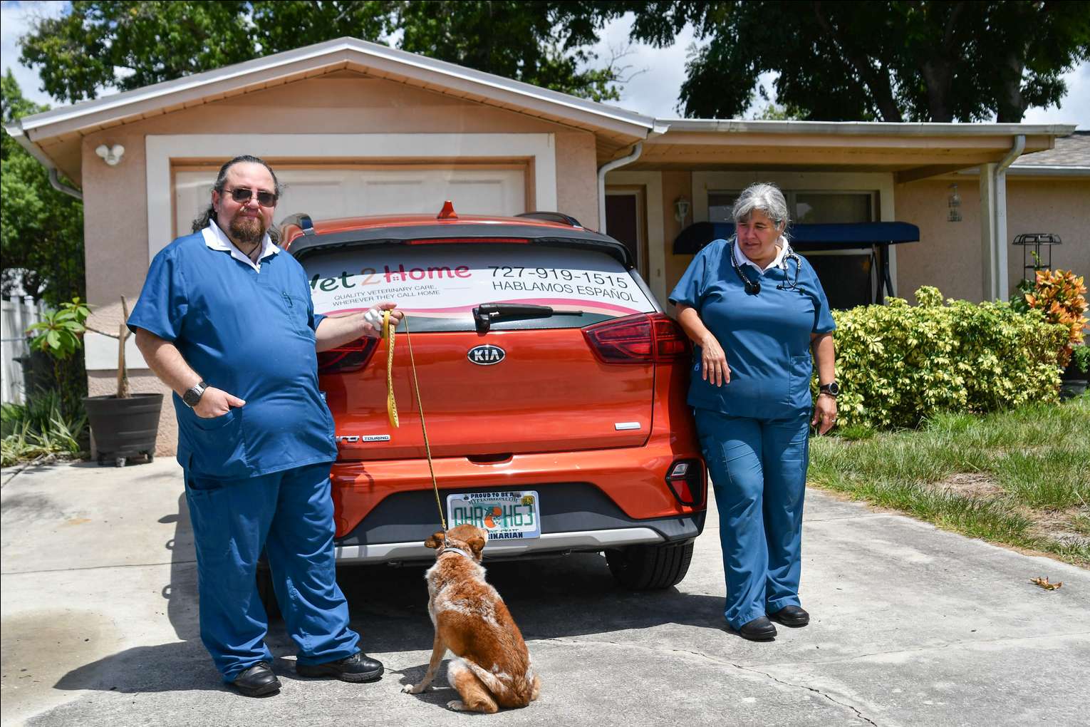 Vet 2 Home team with a dog in front of the mobile vet car