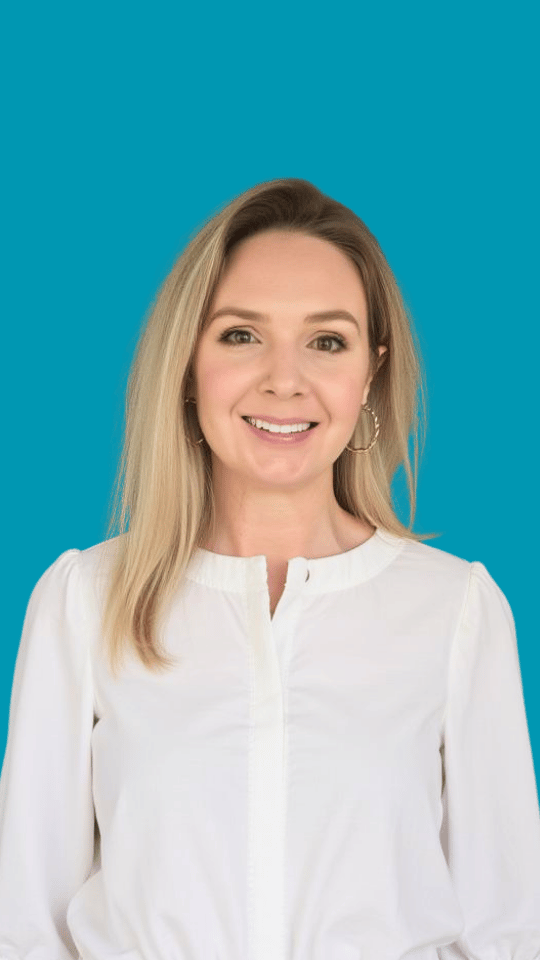 Headshot of Beth D'Arcy, content strategist. A woman with blonde hair smiling at camera against turquoise blue background