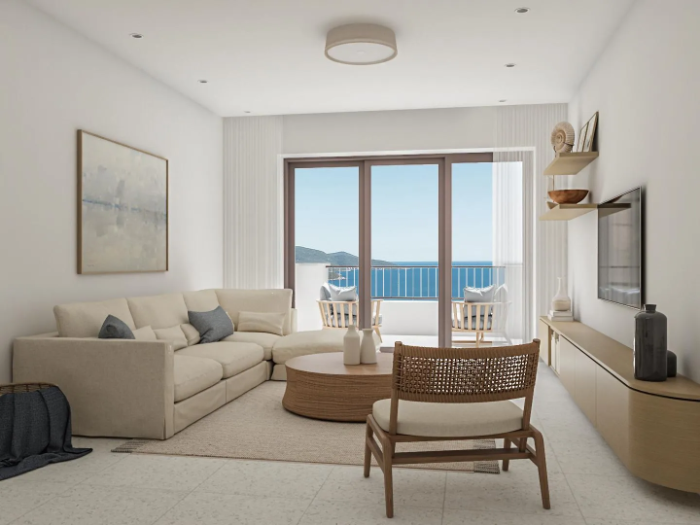 Living room with a corner sofa and sliding doors onto a sea-view terrace