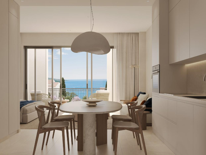 Dining area with a round table, pendant light and terrace doors to the sea
