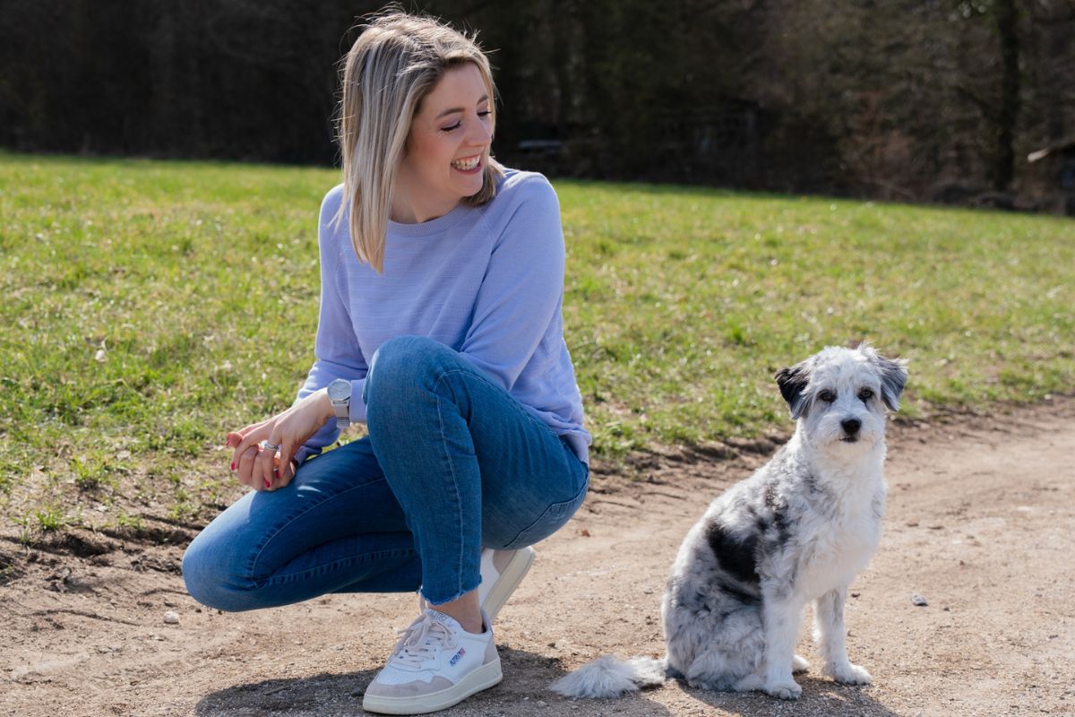 Jasmin Tivadar mit ihrem Hund auf einer Wiese