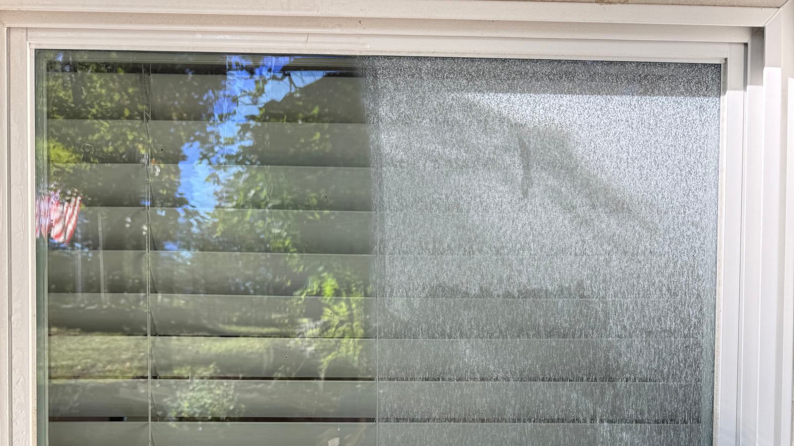 Exterior window glass being washed, soapy water running down the pane