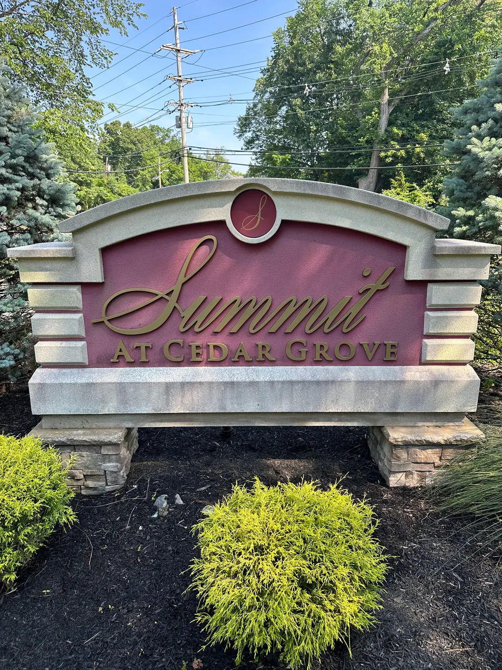 Stone and brick community entrance sign dulled by dirt before cleaning