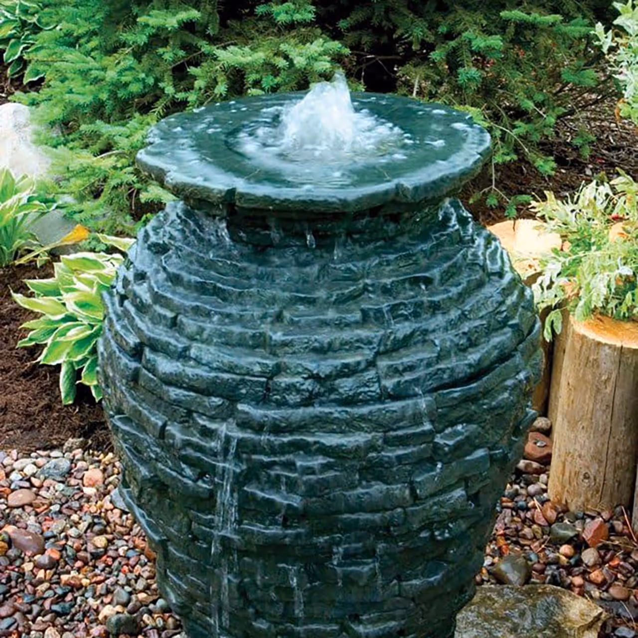 Triscapes custom landscape fountain near me creating a relaxing focal point with natural stone and flowing water.