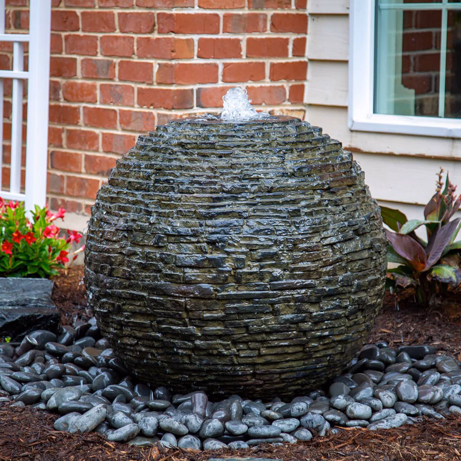 Triscapes custom pondless water feature near me adding natural beauty and relaxing movement to a professionally landscaped outdoor space.