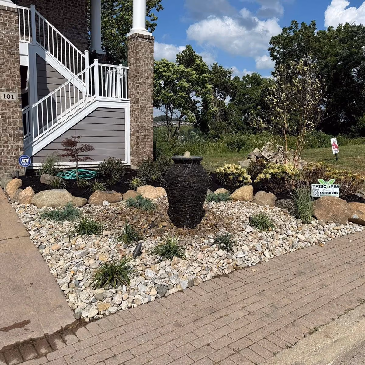 Triscapes custom landscaping near me featuring colorful plant beds, shrubs, and fresh mulch