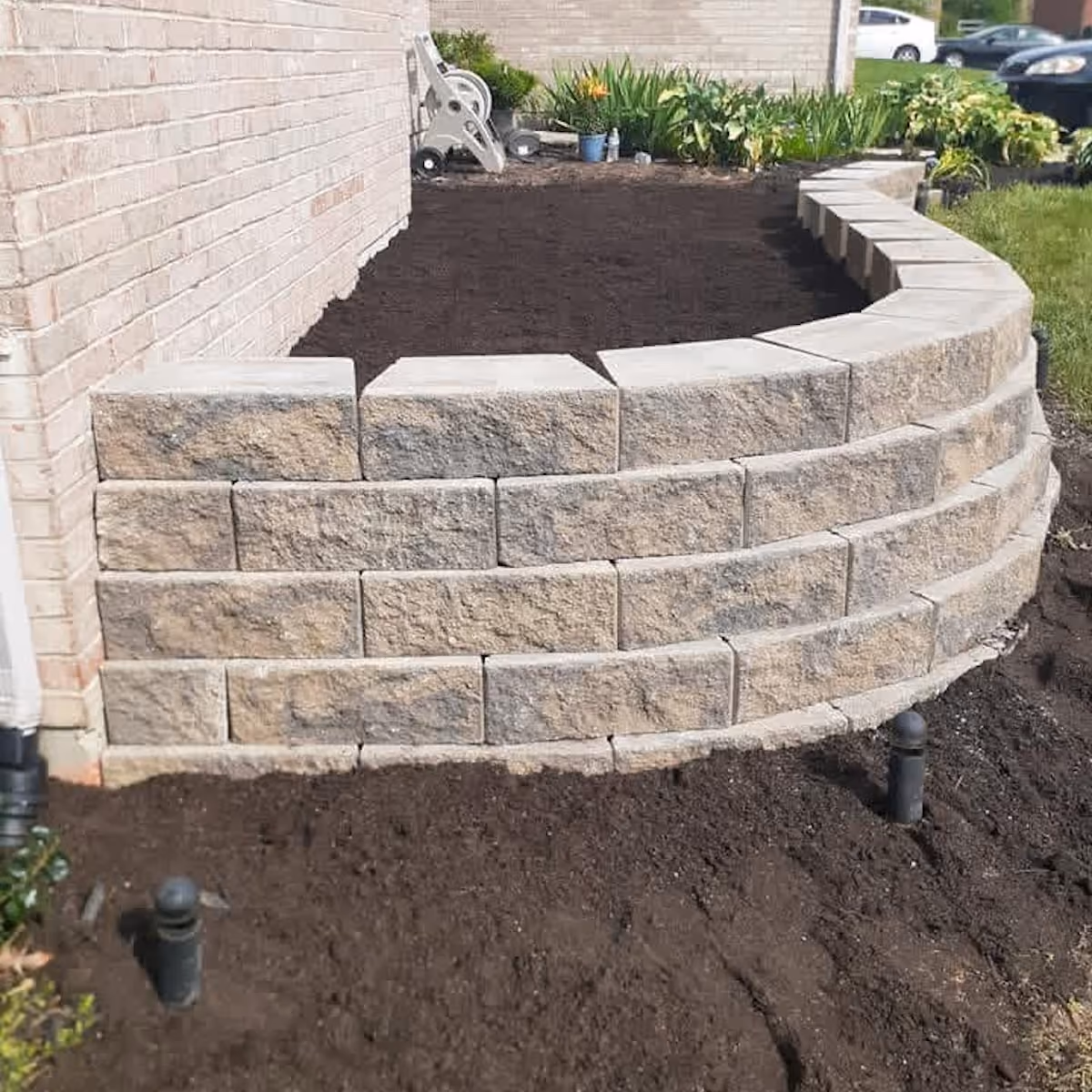Triscapes professional hardscaping near me featuring a custom paver patio and retaining wall