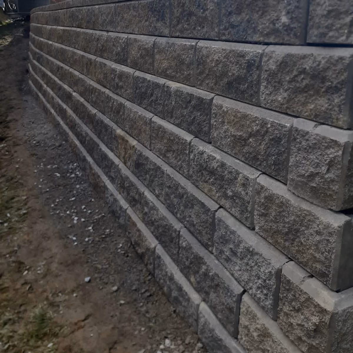 Triscapes paver patio and retaining wall installation creating a functional outdoor living space