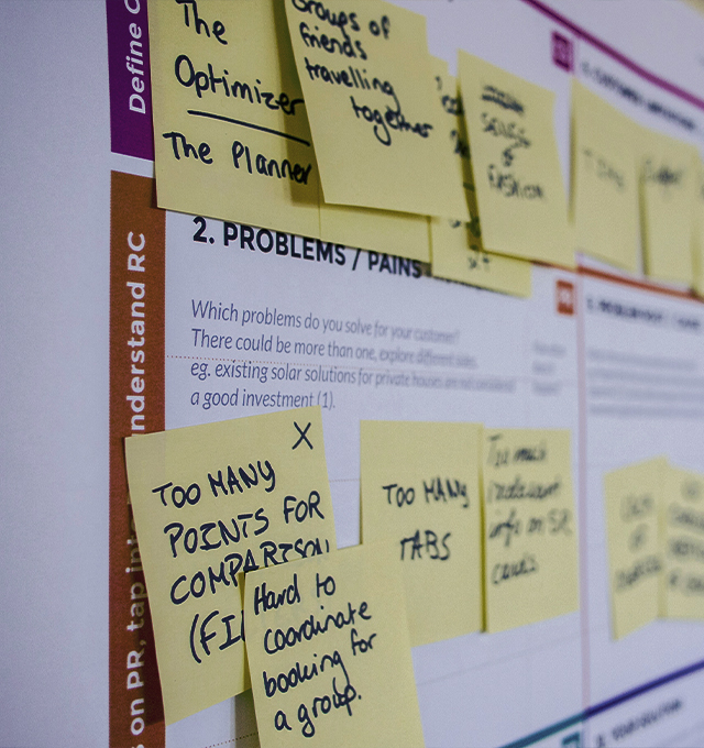 Sticky notes arranged on a strategy planning board during a collaborative workshop, representing brand research, problem solving, and business strategy.