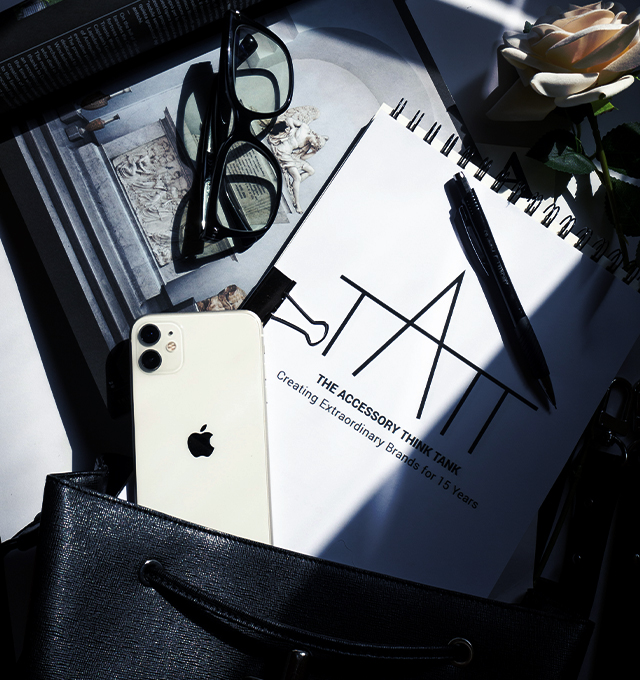 Workspace scene featuring a notebook, glasses, smartphone, and branding materials representing strategy, design, and brand development.