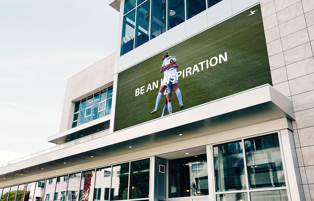 Environmental branding mockup showing a large Over The Wall Fitness advertisement.
