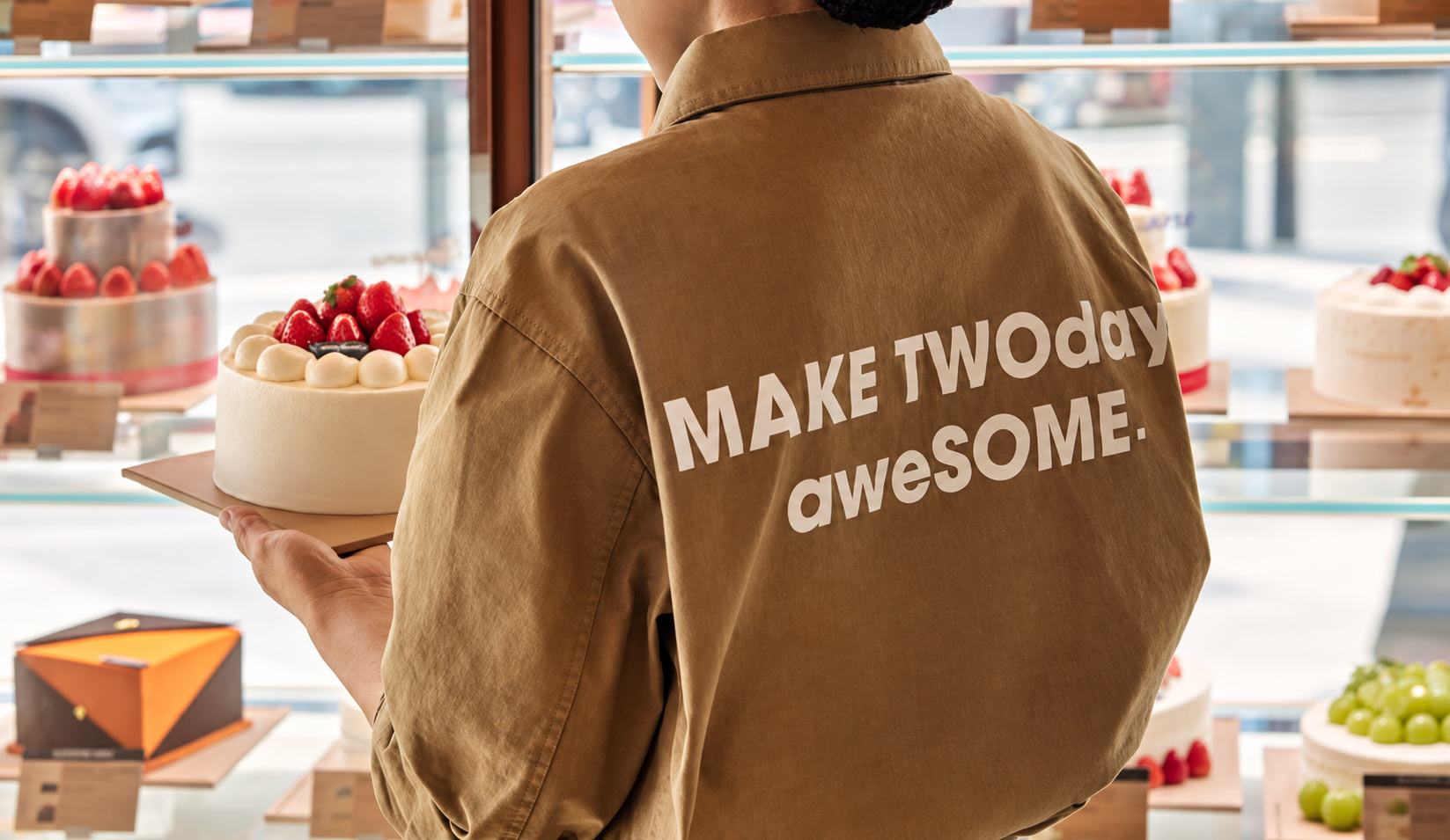 Twosome Place team member placing cake in display