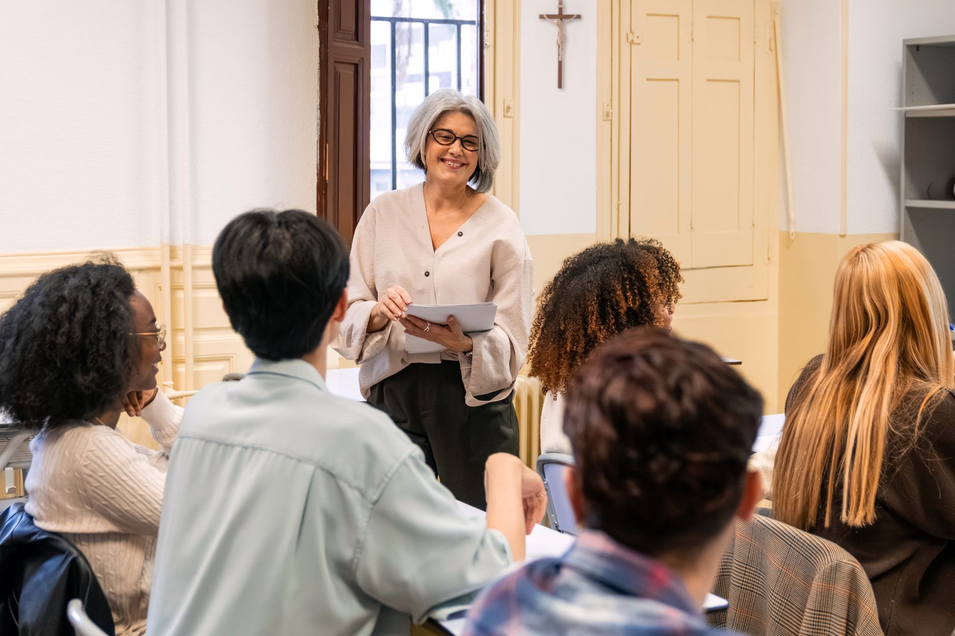 An older woman teaching a room full of teenagers