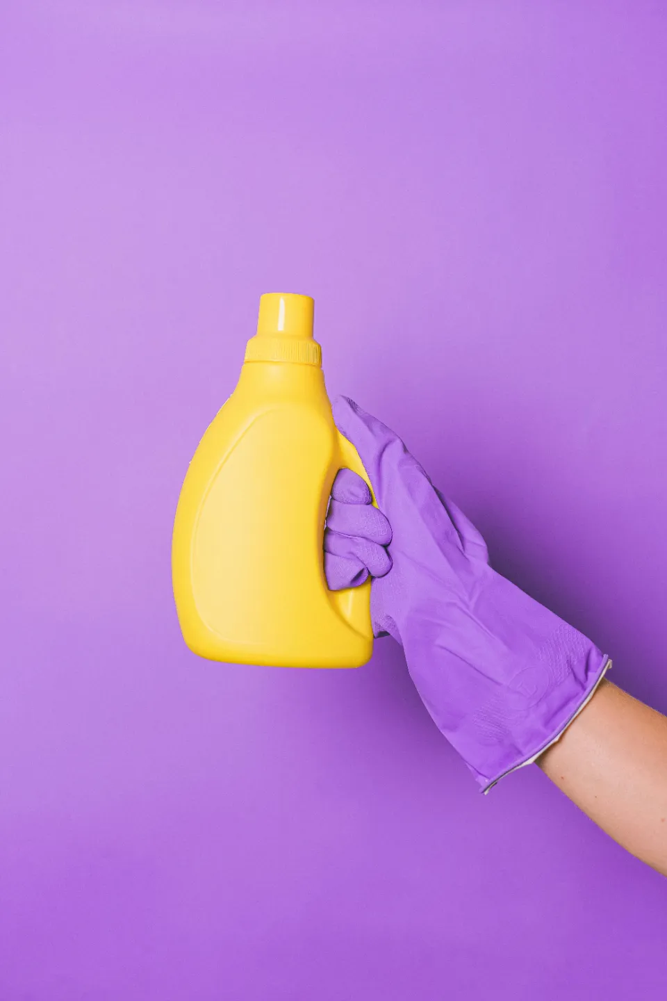 Main gantée de violet tenant un bidon de produit nettoyant Nickel Chrome
