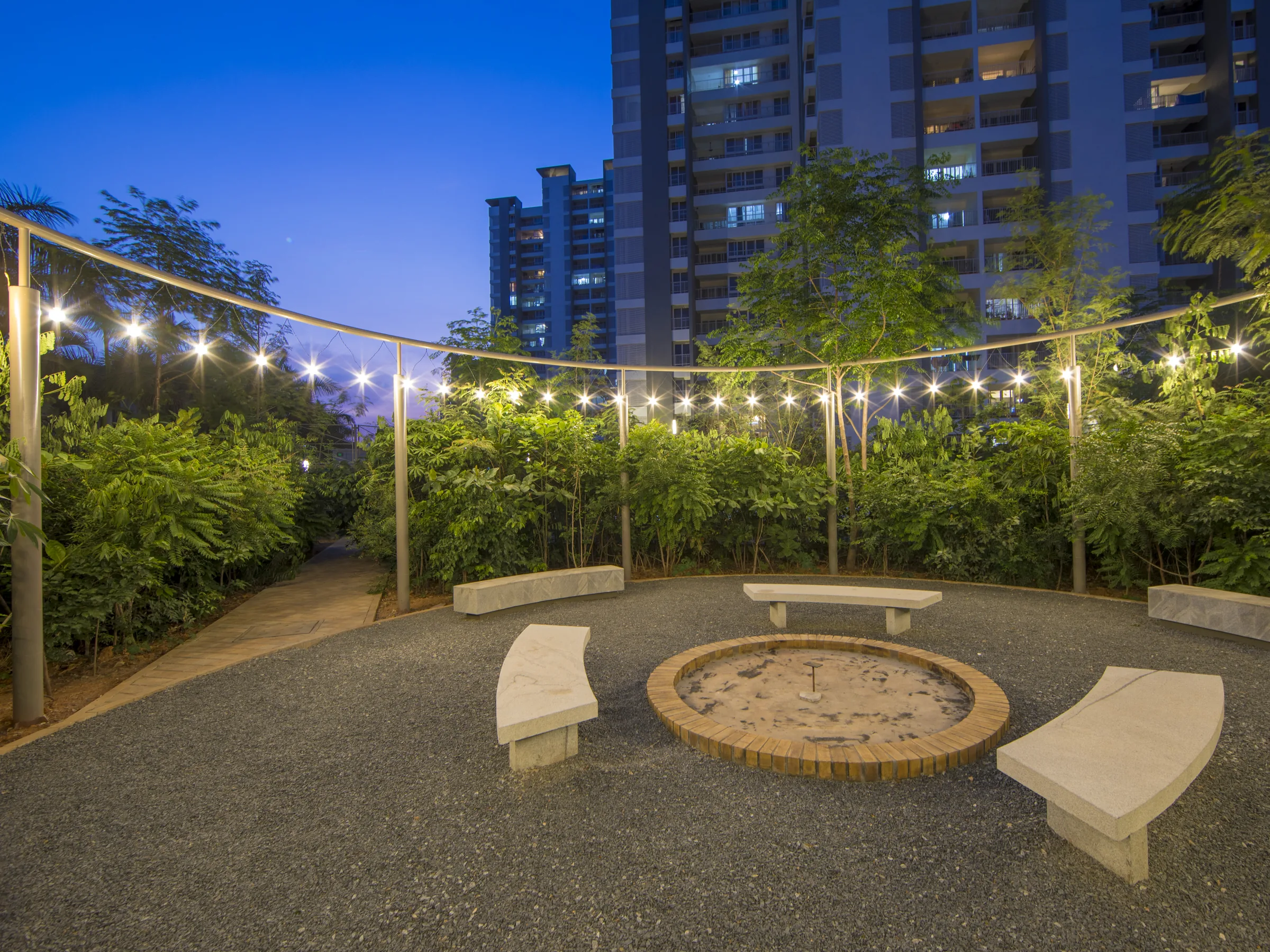 Urban Forest outdoor seating circle with string lights at dusk