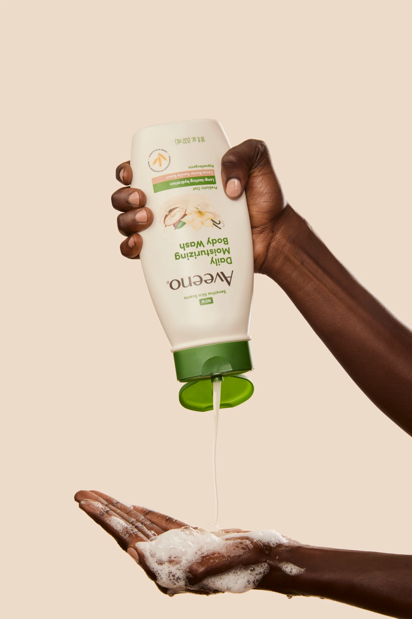Hands dispensing product from an inverted Aveeno bottle.