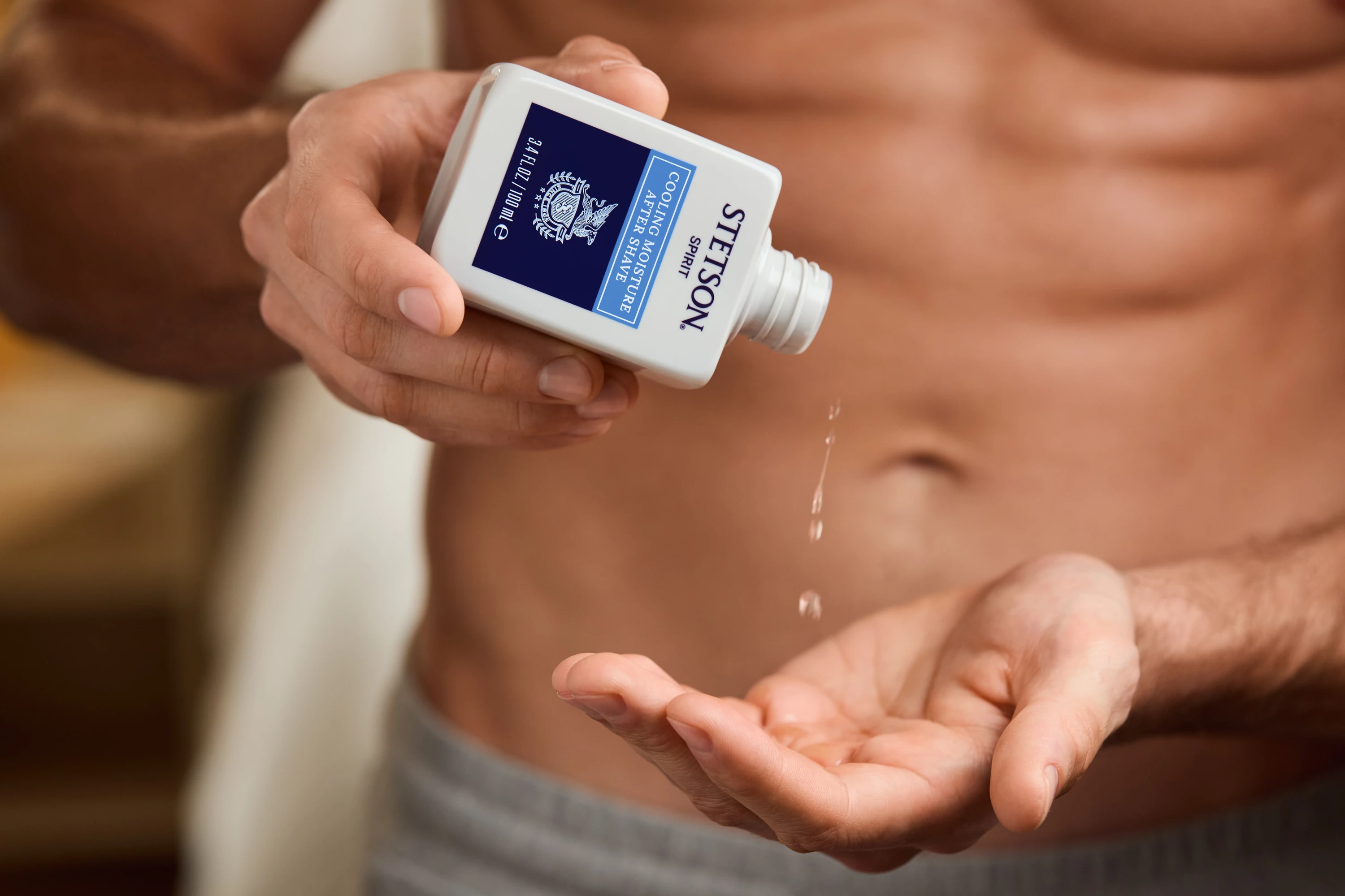 Hands dispensing Stetson aftershave into a palm.