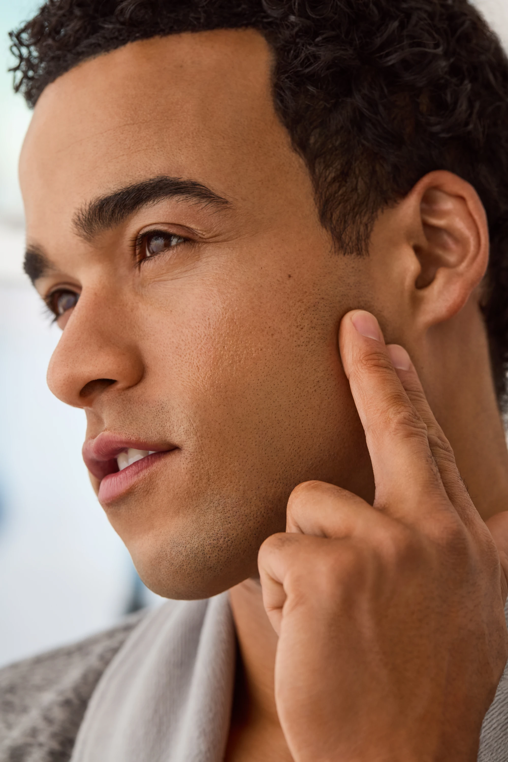 A model touching his cheek in a grooming portrait.