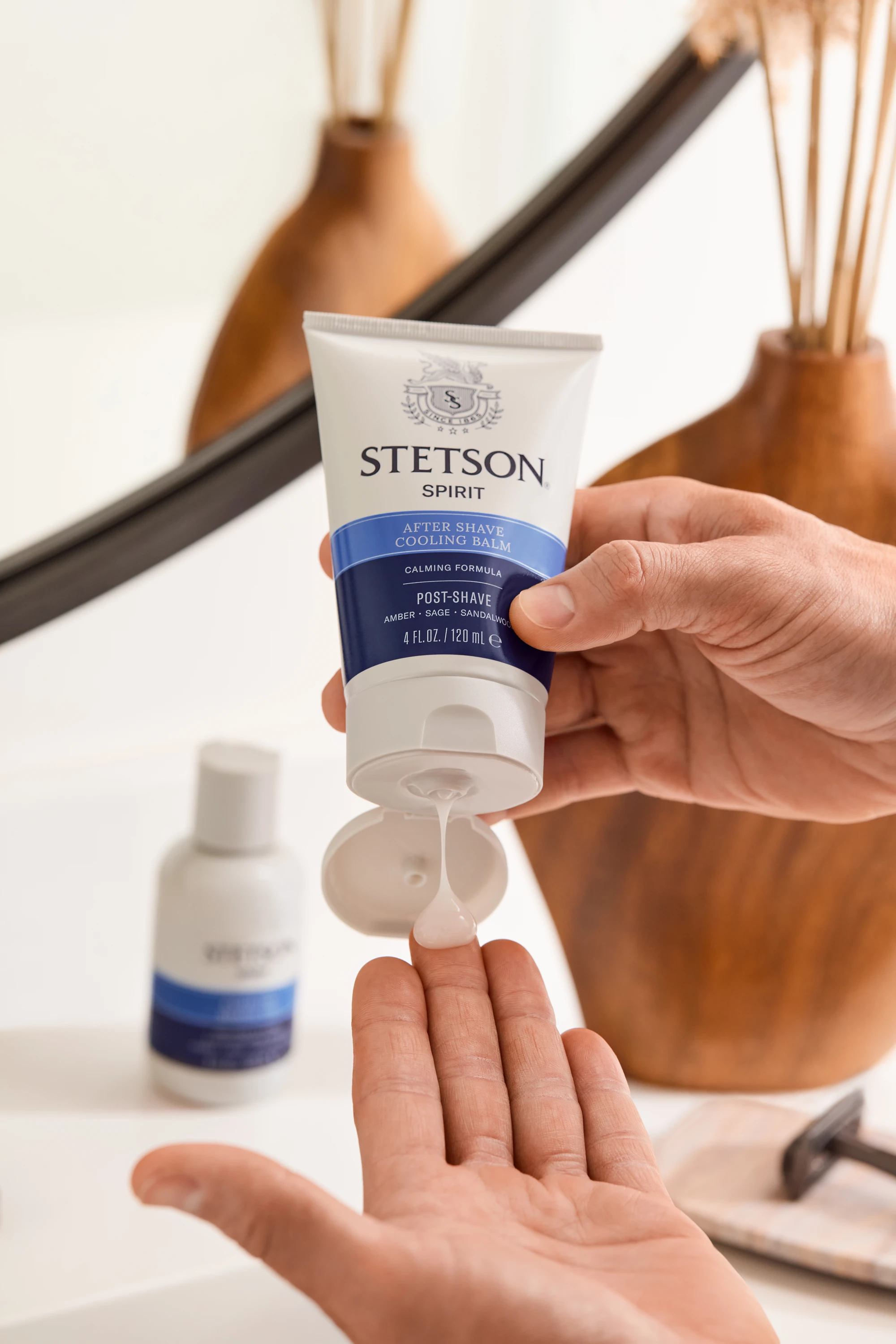 Hands dispensing product from a Stetson tube.