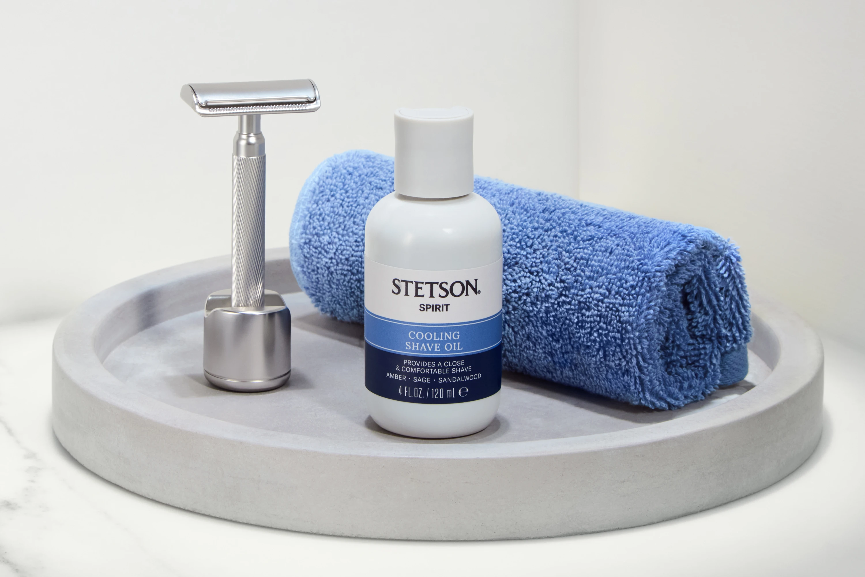 A Stetson bottle beside a razor and rolled blue towel.