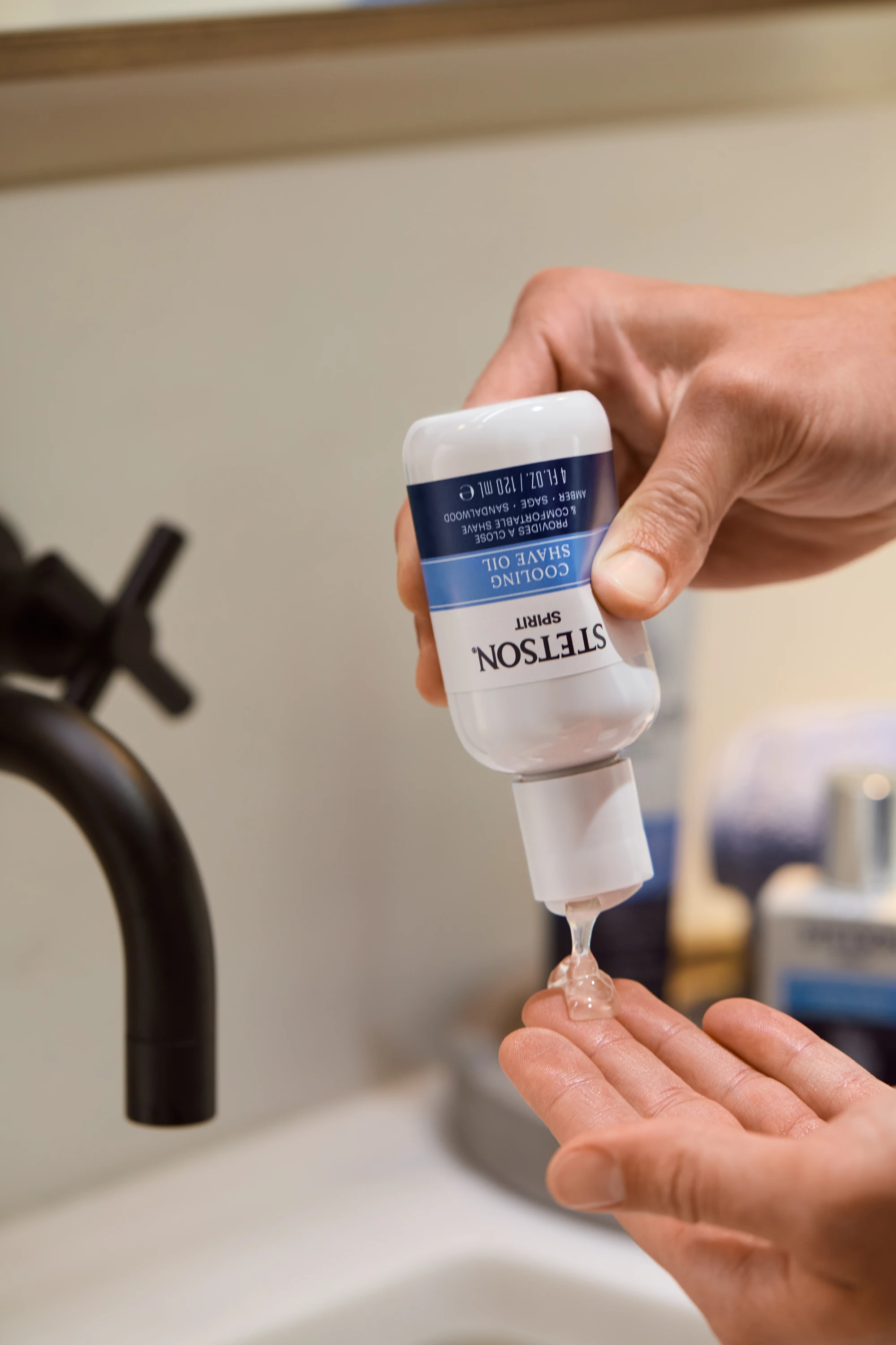 Hands dispensing product from an inverted Stetson tube.