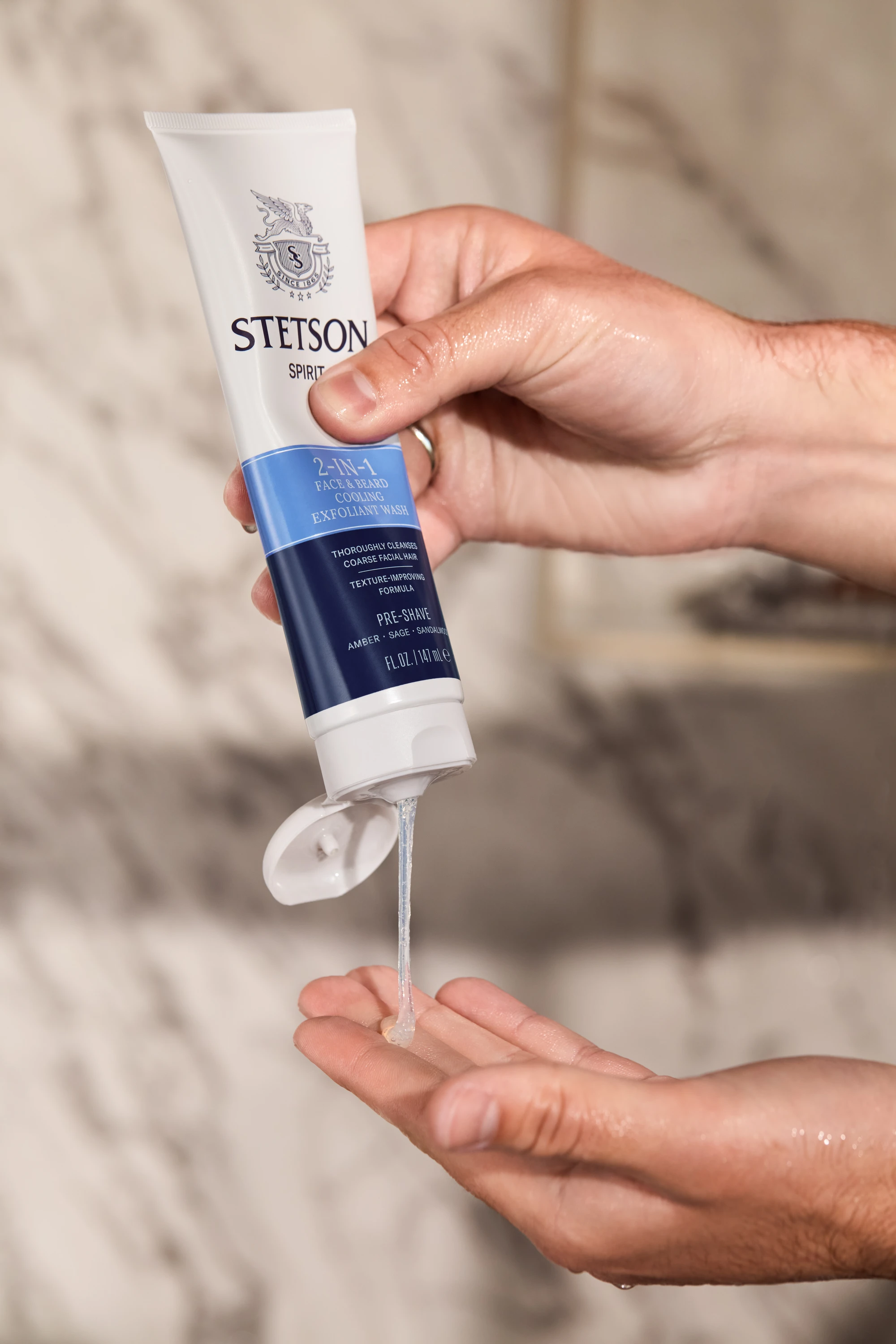 Hands squeezing product from a Stetson tube.