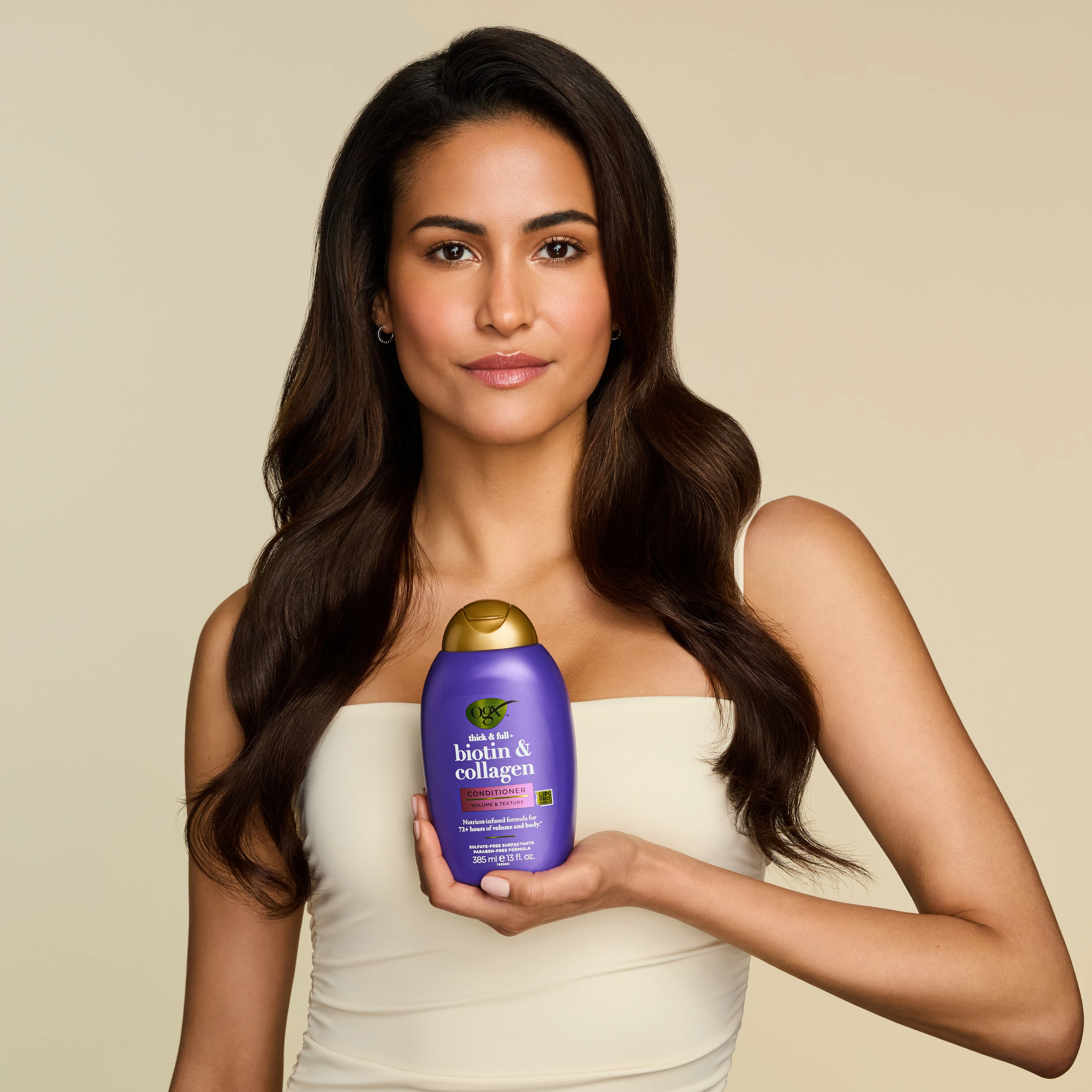A model holding a purple OGX bottle.