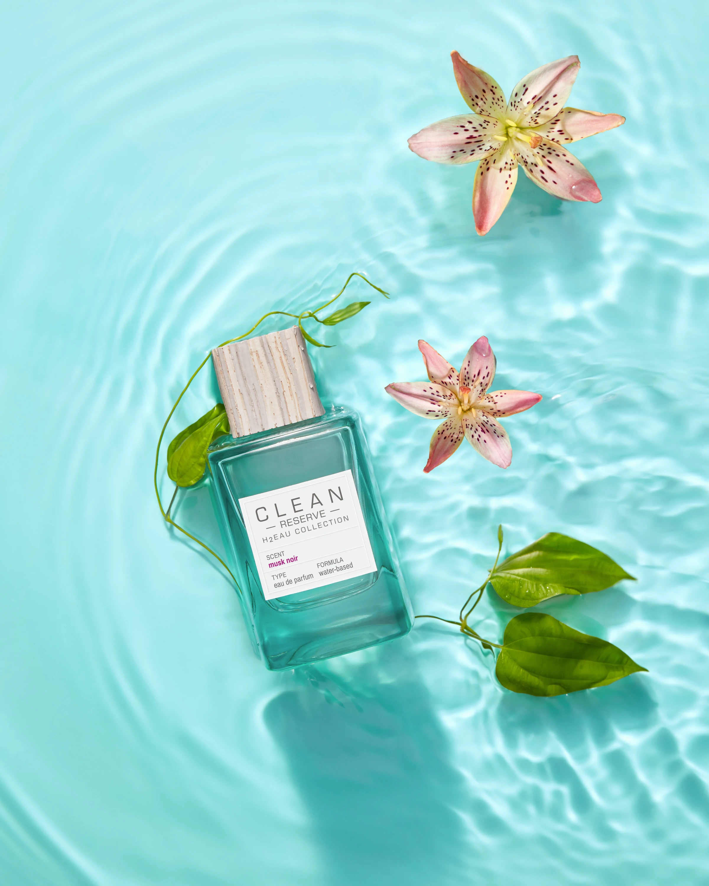 A Clean Reserve bottle floating among flowers and leaves.