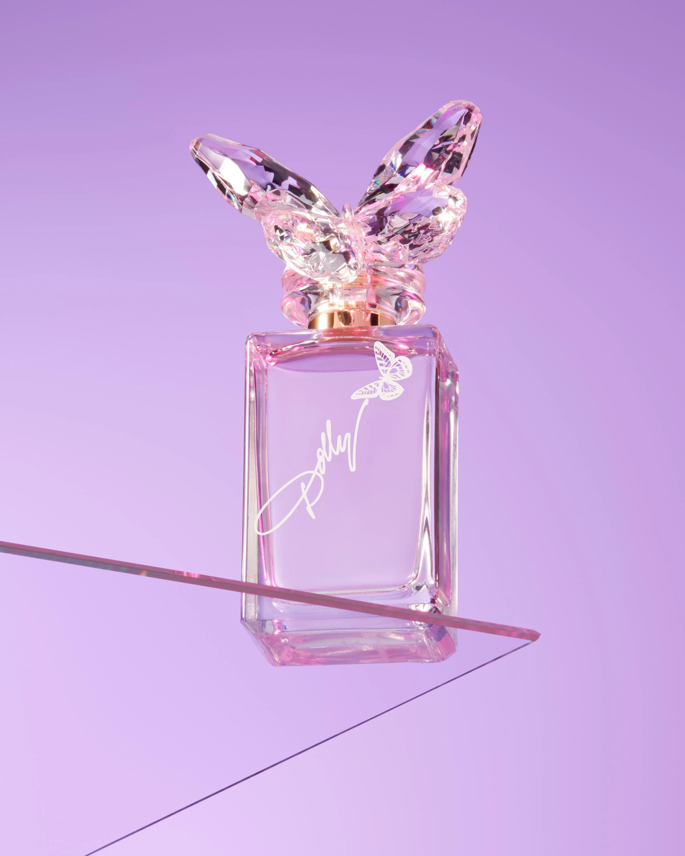 A Dolly Parton fragrance bottle against a purple background.