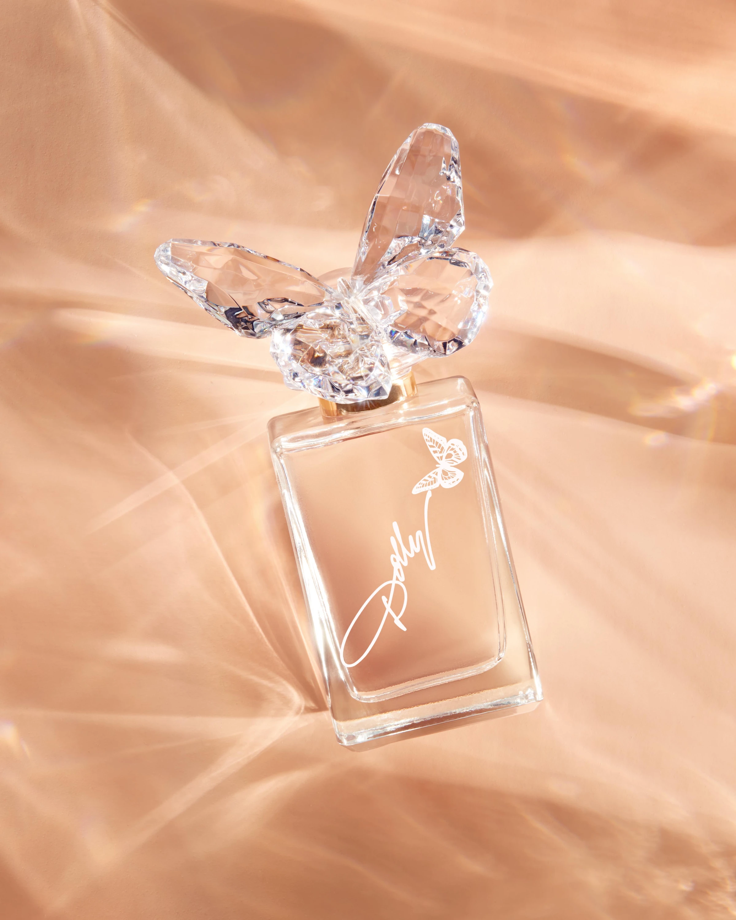 A Dolly Parton bottle casting patterned light on a peach surface.