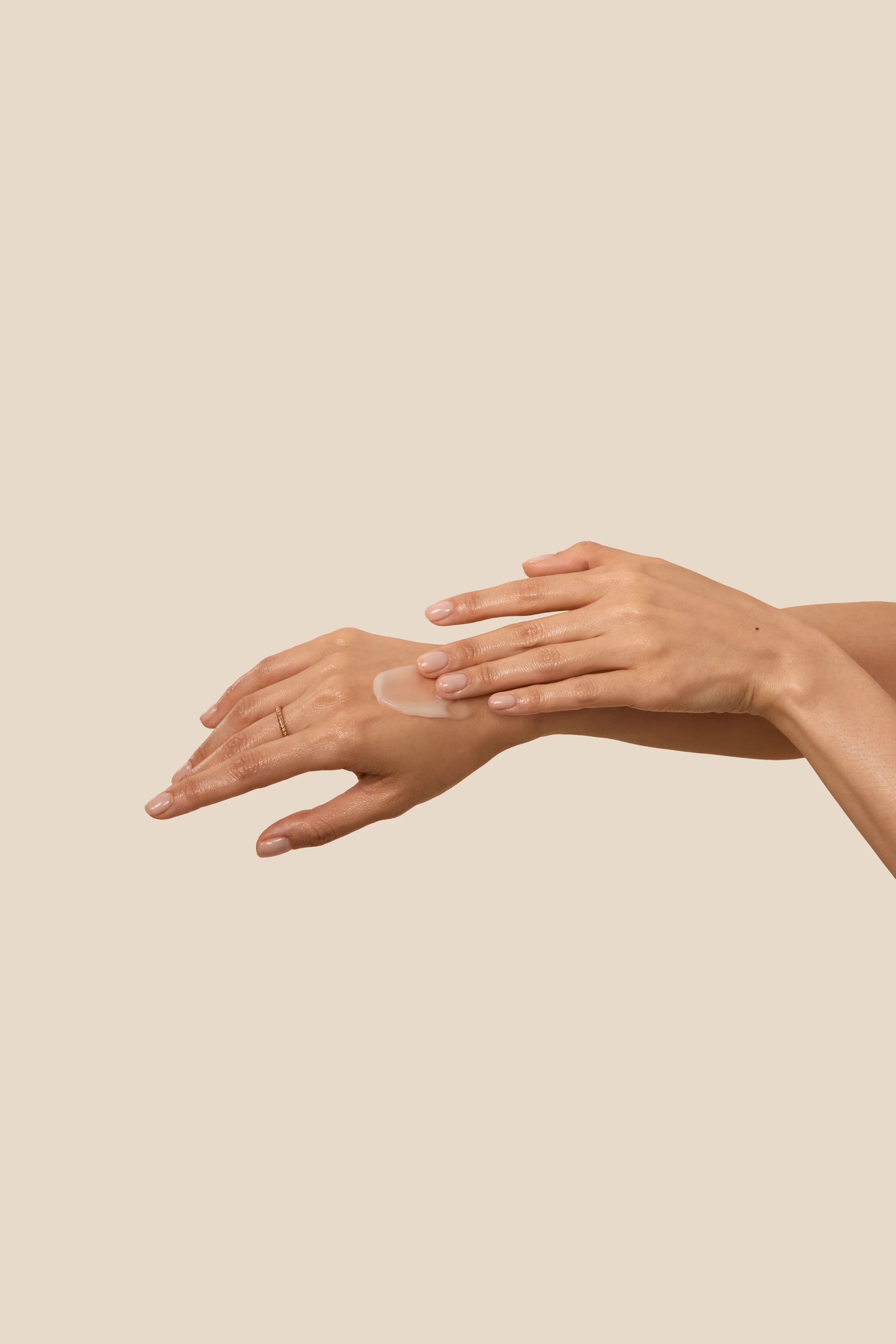 Hands rubbing product into the skin.